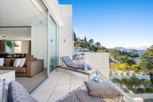 a living room with a balcony with a view of the water at Taupo Penthouse in Taupo