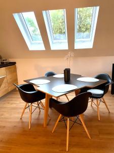 una mesa y sillas en una habitación con tragaluces en Harzpur Lodge - Pure Entspannung in purer Natur en Hahnenklee-Bockswiese