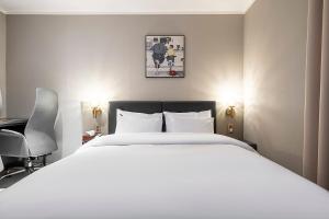 a bedroom with a large white bed and a desk at Brown Dot Hotel Osan in Osan