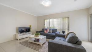 a living room with a couch and a tv at Anne Street Monte - Vista in Port Macquarie