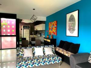 a living room with a couch and a kitchen at CASA GUME - Departamentos con 2 habitaciones para 4 personas in Oaxaca City