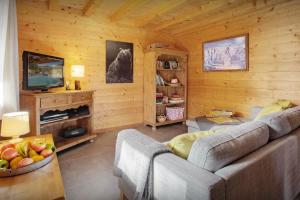 a living room with a couch and a television at Chalet Batieu - OVO Network in La Clusaz