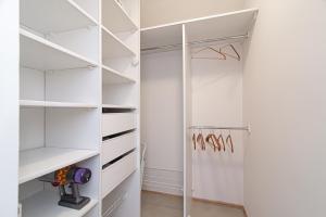 a white walk in closet with white shelves at Slow-down, relax, take it easy in artsy Oasy in Vilnius