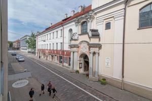 a group of people walking down a street next to a building at Slow-down, relax, take it easy in artsy Oasy in Vilnius
