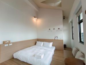 sypialnia z białym łóżkiem w pokoju w obiekcie 日日和 w mieście Tainan