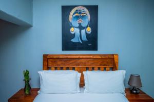 Nyumbani Palace Arusha في أروشا: غرفة نوم زرقاء مع سرير مع وسائد بيضاء