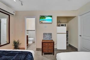 a bedroom with a bed and a bathroom with a refrigerator at Hollywood Broadwalk Beach Walk Holiday Retreat in Hollywood