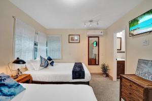 a hotel room with two beds and a television at Hollywood Broadwalk Beach Walk Holiday Retreat in Hollywood