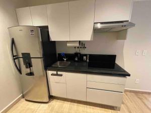 a kitchen with a refrigerator and a sink at Ocean view apartment close to de beach and 5th Av in Playa del Carmen