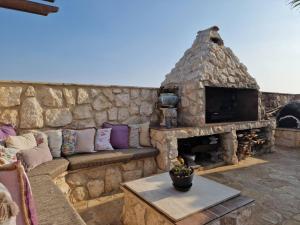 Alaminos的住宿－Oikos Selinolithos，石墙、沙发和石制壁炉