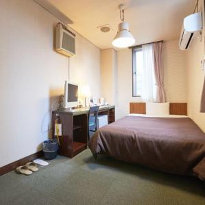 1 dormitorio con 1 cama y escritorio con ordenador en Hotel Select Inn Nishinasuno, en Nasushiobara