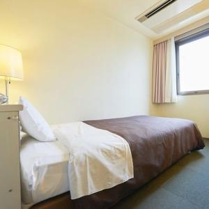 a bedroom with a bed in a room with a window at Hotel Select Inn Nishinasuno in Nasushiobara