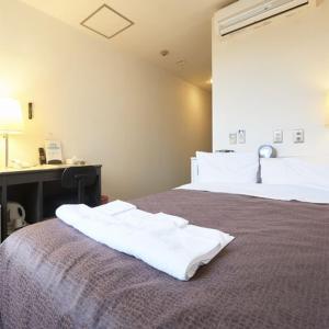 a bedroom with two beds with white towels on the bed at Hotel Select Inn Nishinasuno in Nasushiobara