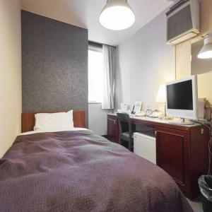 1 dormitorio con 1 cama y escritorio con ordenador en Hotel Select Inn Nishinasuno, en Nasushiobara