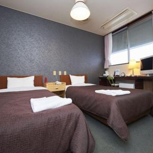 ein Hotelzimmer mit 2 Betten und einem Fenster in der Unterkunft Hotel Select Inn Nishinasuno in Nasushiobara