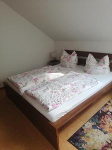 a bedroom with a bed with white sheets and pillows at Haus Lebensart Bansin in Neu Sallenthin