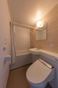 a bathroom with a toilet and a sink and a mirror at Matto Terminal Hotel in Hakusan