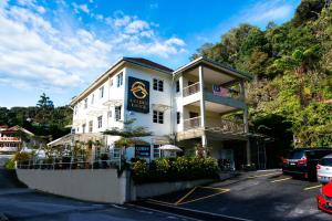 un edificio blanco con un cartel en un estacionamiento en Golden Lodge, en Tanah Rata