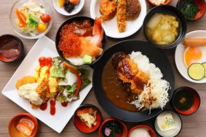 a table topped with plates of food and bowls of food at Dormy Inn Kanazawa Natural Hot Spring in Kanazawa