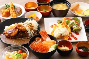 a table with plates of food and bowls of food at Dormy Inn Kanazawa Natural Hot Spring in Kanazawa