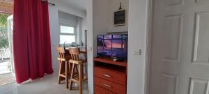 a living room with a television and a red curtain at Coco Lux Mon Amour in Grand Baie