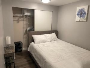a bedroom with a bed with white sheets and a lamp at 1BR Condo, Air Conditioning, FREE Parking, Rooftop View in Seattle