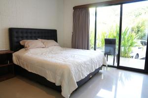 a bedroom with a bed and a large window at Doris Seminyak Studio in Seminyak