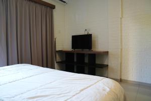 a bedroom with a bed and a television on a shelf at Doris Seminyak Studio in Seminyak