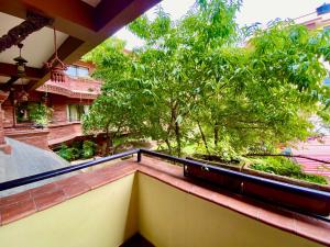 un balcón con un árbol en la parte superior de un edificio en Hotel Siddhi Manakamana, en Katmandú