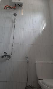 uma casa de banho com um WC e um chuveiro em BERYL HOMESTAY em Tarutung