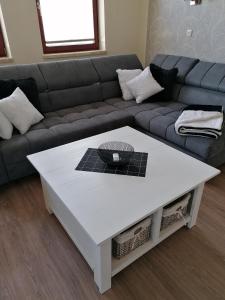 ein Wohnzimmer mit einem Sofa und einem weißen Couchtisch in der Unterkunft Ferienwohnung Wegner in Trassenheide