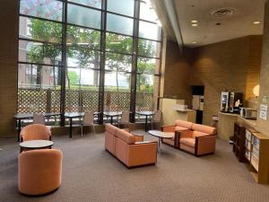 a library with chairs and tables and a large window at Smile Hotel Yonago in Yonago