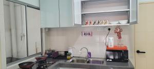 een keuken met een wastafel en een magnetron bij Casa Klebang @ Ipoh homestay in Chemor