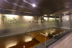 a room with a glass wall with a tennis court at Dormy Inn Kanazawa Natural Hot Spring in Kanazawa