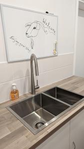 a kitchen sink with aigraphy on the wall above it at Amberlyn Escapes in Killcare