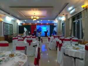 a banquet hall with white tables and red chairs at Yen Nhi Hotel Ninh Binh in Ninh Binh +110 photos