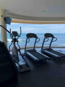three exercise bikes in a gym with a view of the ocean at Ocean Front Condo @ Las Olas Grand in Rosarito