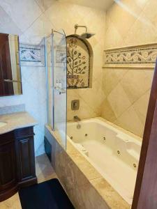 a bathroom with a tub and a shower and a sink at Ocean Front Condo @ Las Olas Grand in Rosarito