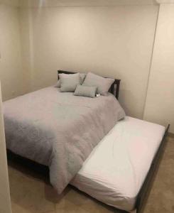 a large bed with white sheets and pillows on it at Ocean Front Condo @ Las Olas Grand in Rosarito