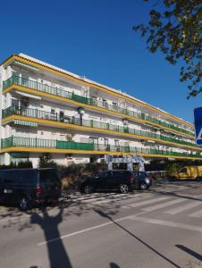 a large building with cars parked in a parking lot at Appartement Empuriabrava in Empuriabrava