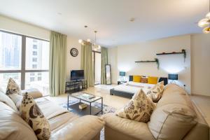a large living room with a couch and a tv at Perfect studio near the beach JBR in Dubai