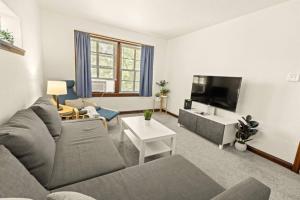 ein Wohnzimmer mit einem Sofa und einem Flachbild-TV in der Unterkunft Cozy 1-bedroom apartment with free parking in Saint Louis