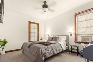 a white bedroom with a bed and a window at Cozy 1-bedroom apartment with free parking in Saint Louis