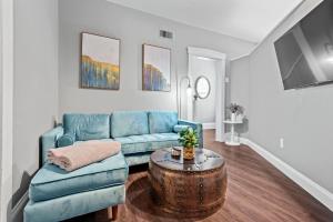 ein Wohnzimmer mit einem blauen Sofa und einem Tisch in der Unterkunft Main Street Living! 2 Bedroom Unit right On Main! in St. Charles