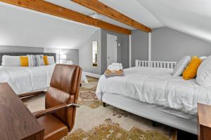 a bedroom with two beds and a chair at Main Street Living! 2 Bedroom Unit right On Main! in St. Charles