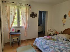 - une chambre avec un lit, une table et une fenêtre dans l'établissement Maison Parc Ducup, à Perpignan