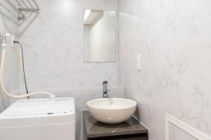 a white bathroom with a sink and a mirror at The Sanctus Ebisu in Tokyo