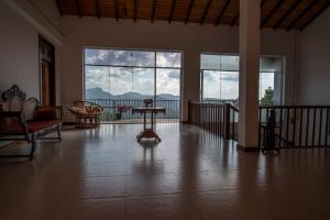 ein Wohnzimmer mit einem Tisch und großen Fenstern in der Unterkunft Sky Lodge in Kandy