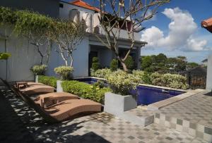a house with a patio and a swimming pool at Doris Seminyak Studio in Seminyak