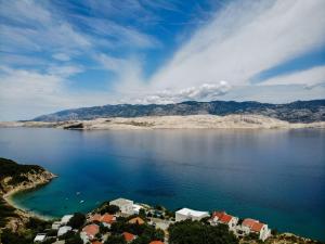 a view of a large body of water with houses at Villa Pag Dubrava Relax with Pool in Pag
